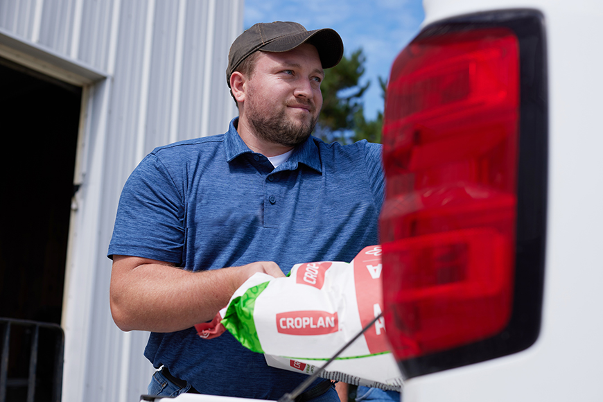 Farmer loading CROPLAN seed bags into his pickup truck.
