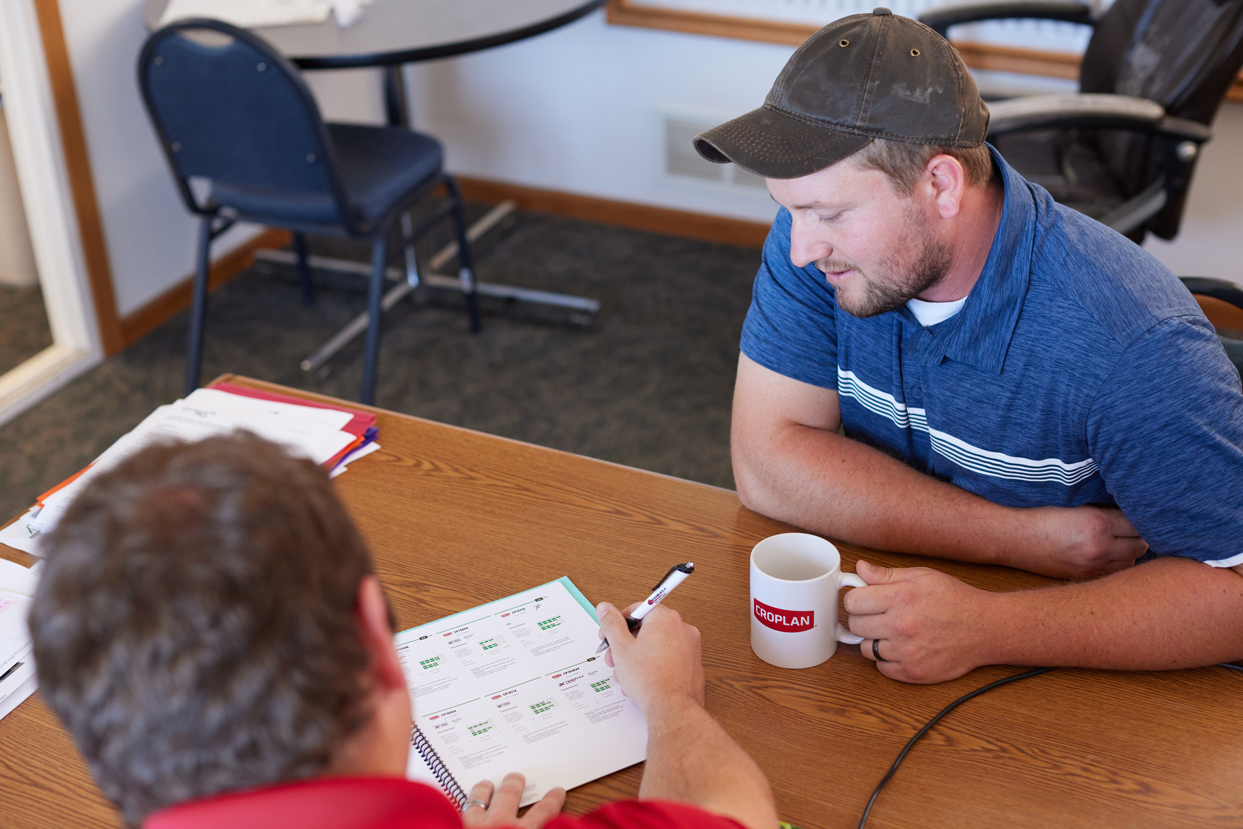 Farmer and retailer having a discussion at a desk.