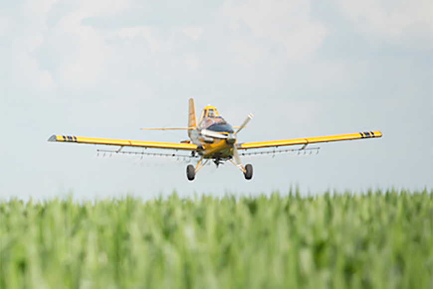 Aerial crop spray plane flying over corn field