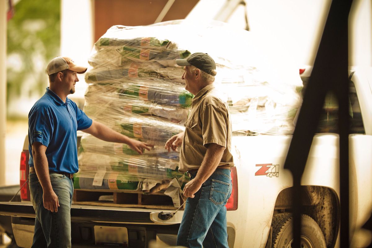 WinField United retailer and farmer talking near a truckload of CROPLAN seed.