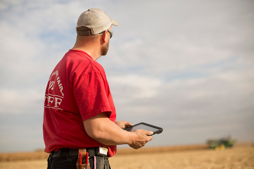 Man using tablet and looking at field