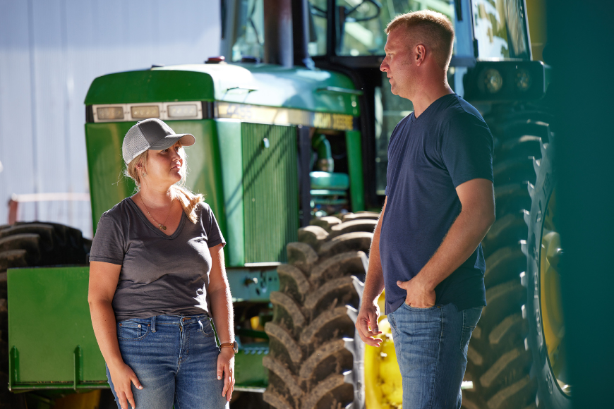 WinField United representative and grower standing in front of a tractor talking