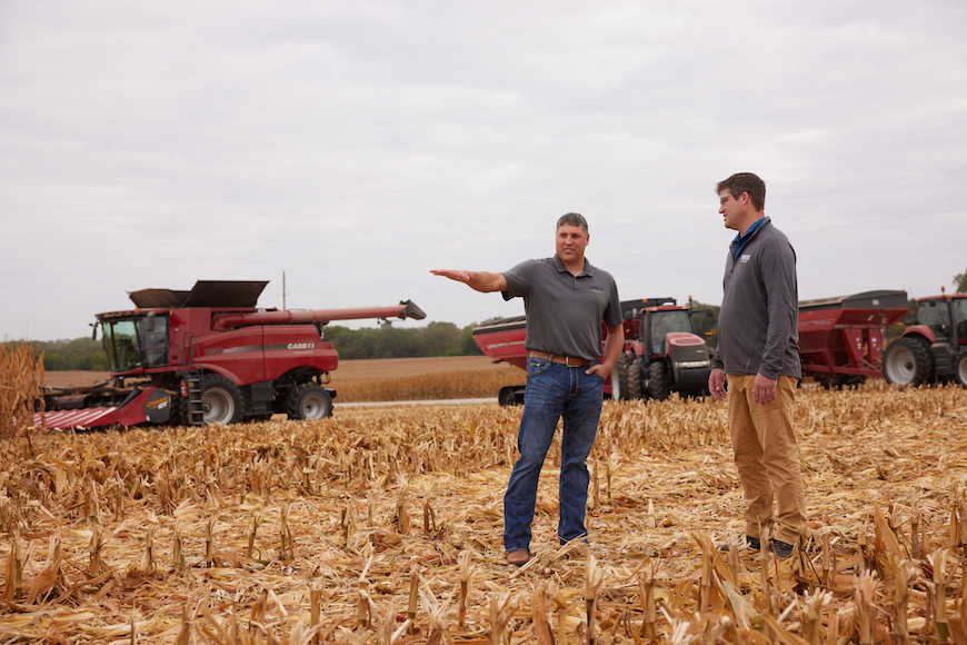 Two men talking in a harvested corn field