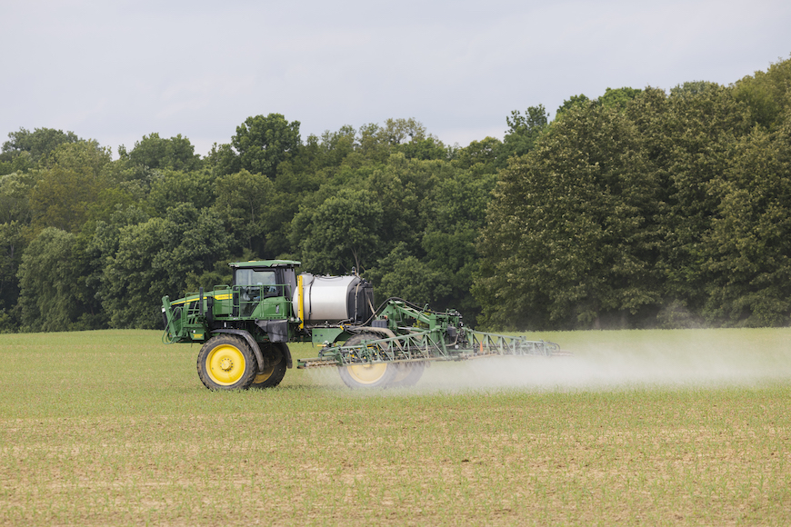 Sprayer in field applying adjuvant