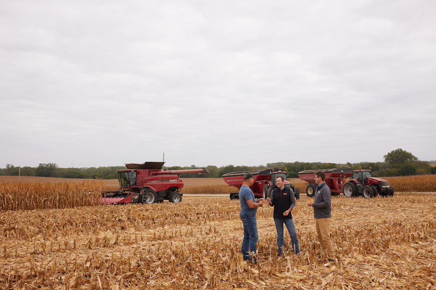 Retailers and grower standing in partly harvested field