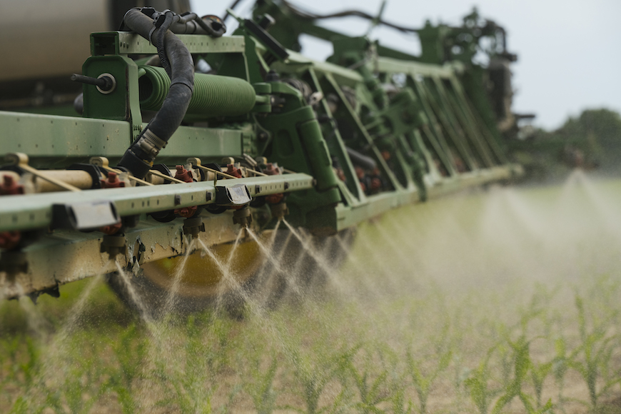 Sprayer making a spring application to corn field