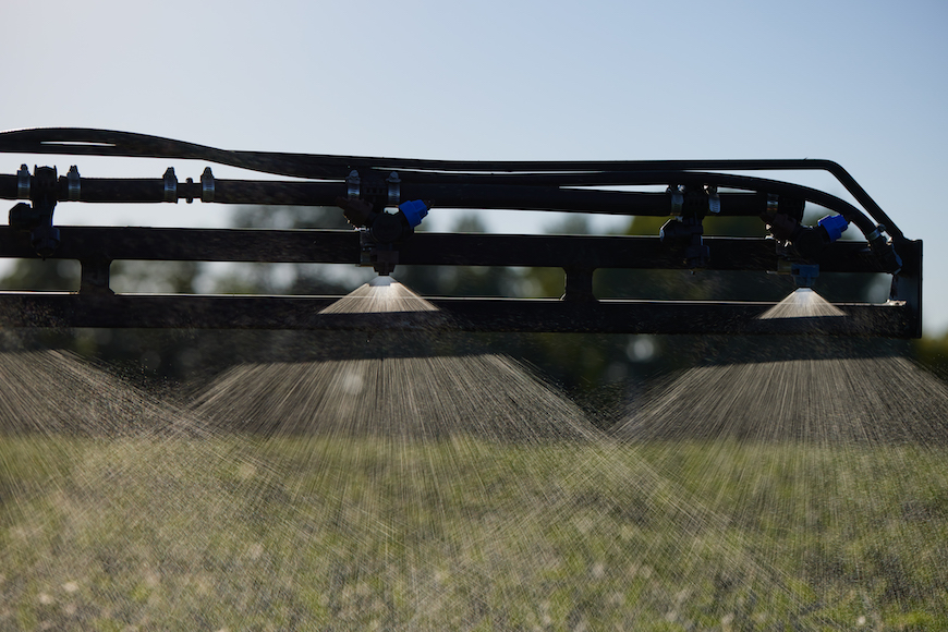 Spraying fungicide on mid-season corn field