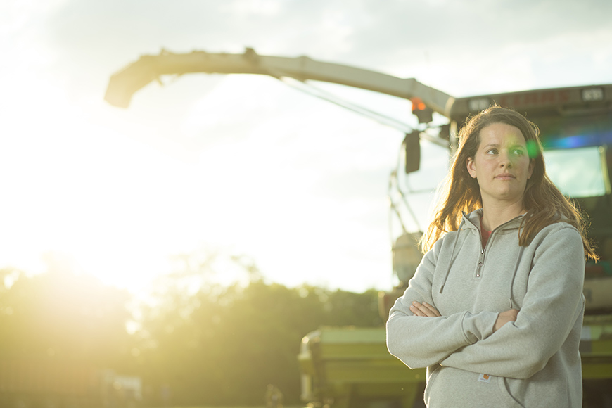 Woman standing in front of farm equipment