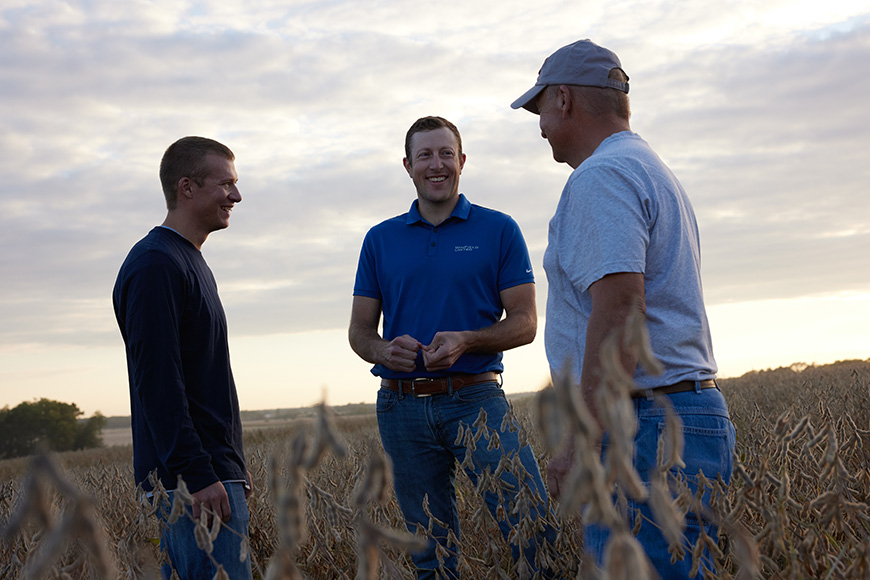 WinField United advisor talks with growers in a soybean field.