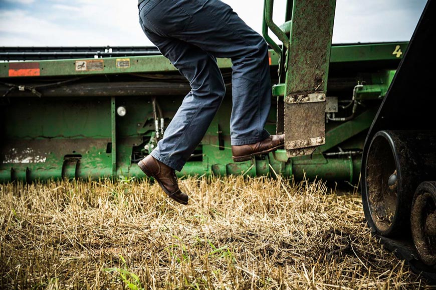 Man stepping into the cab of a combine