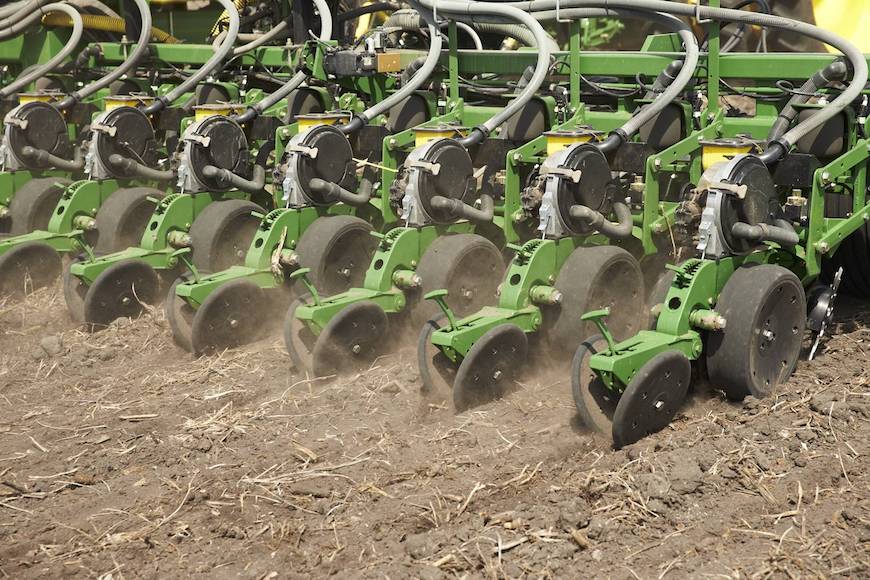 Green planter planting seed in-furrows